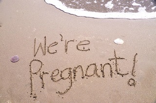 We're pregnant written in sand